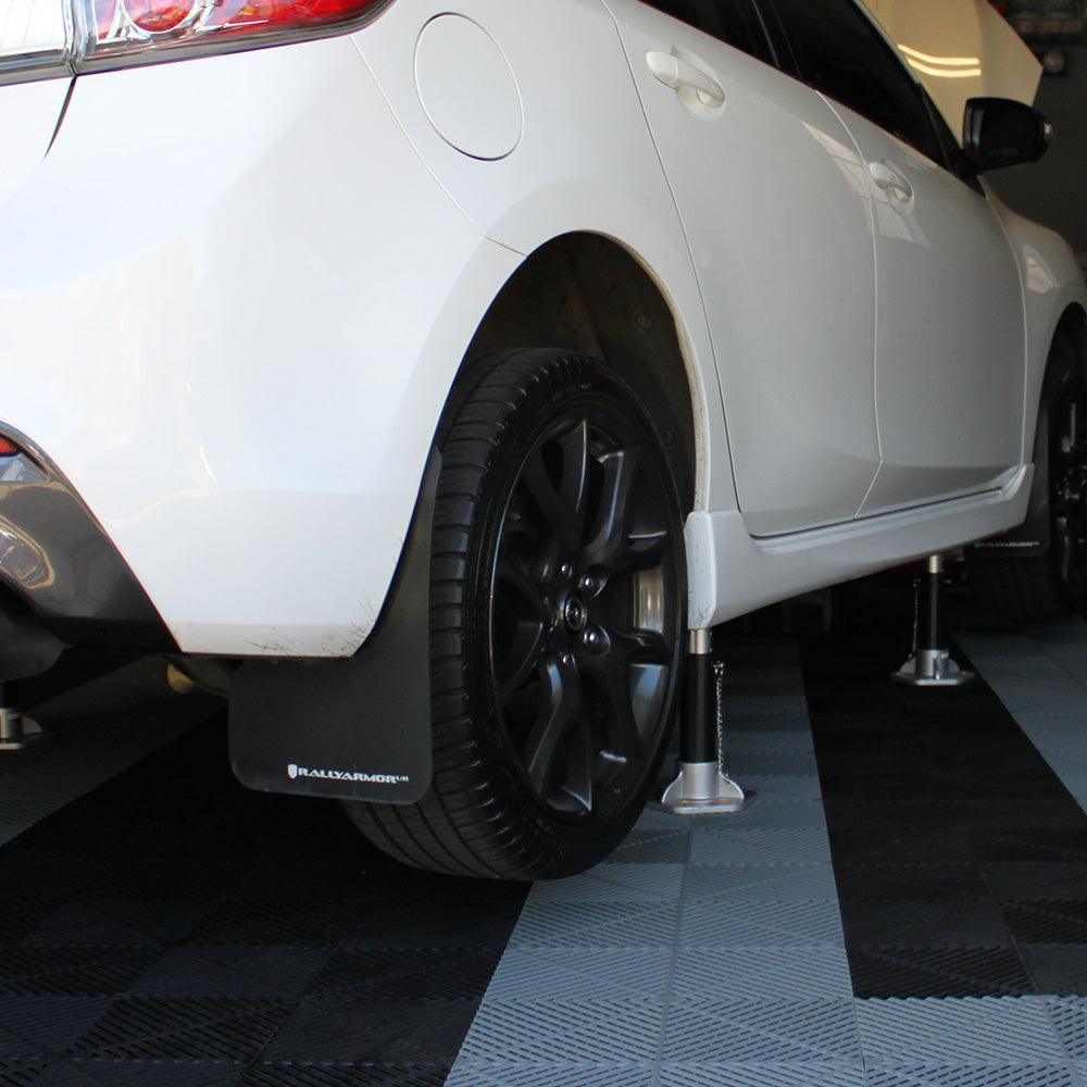 White car on black and white garage floor tiles