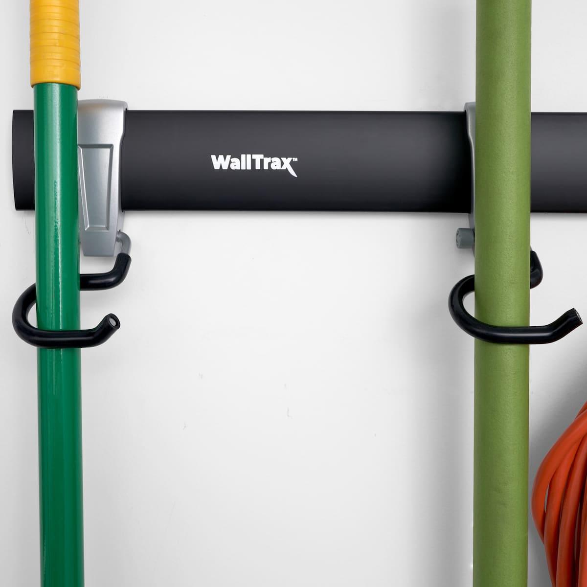 Close-up of hooks holding broom and rake