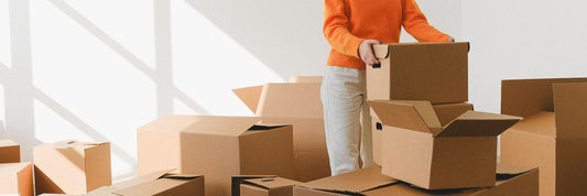 person surrounded by cardboard boxes