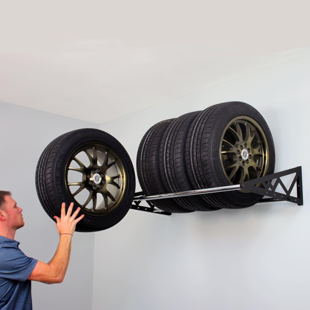 Person stacking spare tires on tire rack