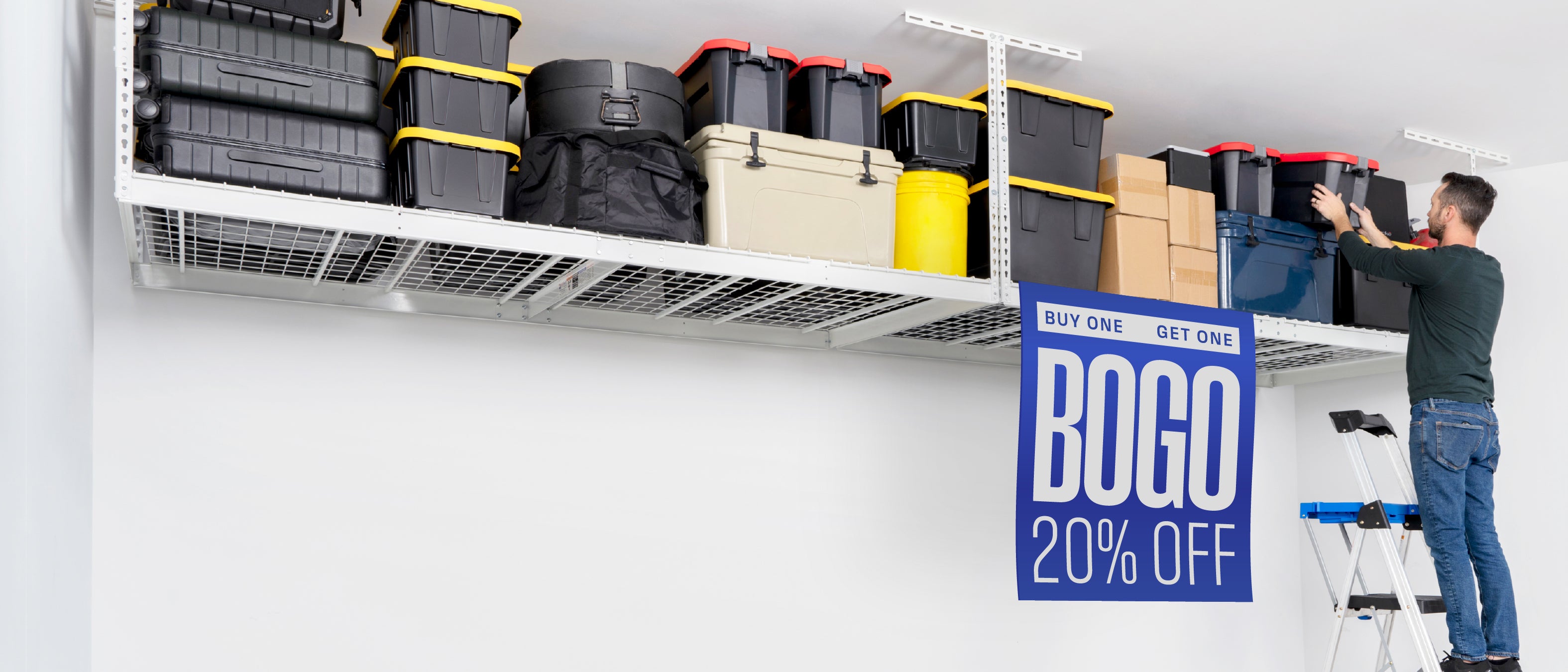 A man on a step ladder organizes storage bins on a white overhead rack. A large blue 'BOGO 20% OFF' sale sign hangs off the front of the overhead rack.