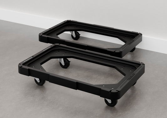 Two empty black plastic bin dollies with casters placed side-by-side on a concrete floor.