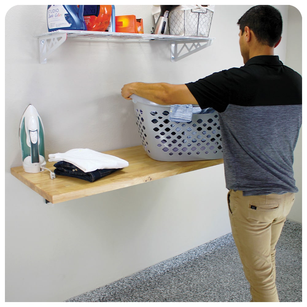 person standing in front of wall mounted workbench
