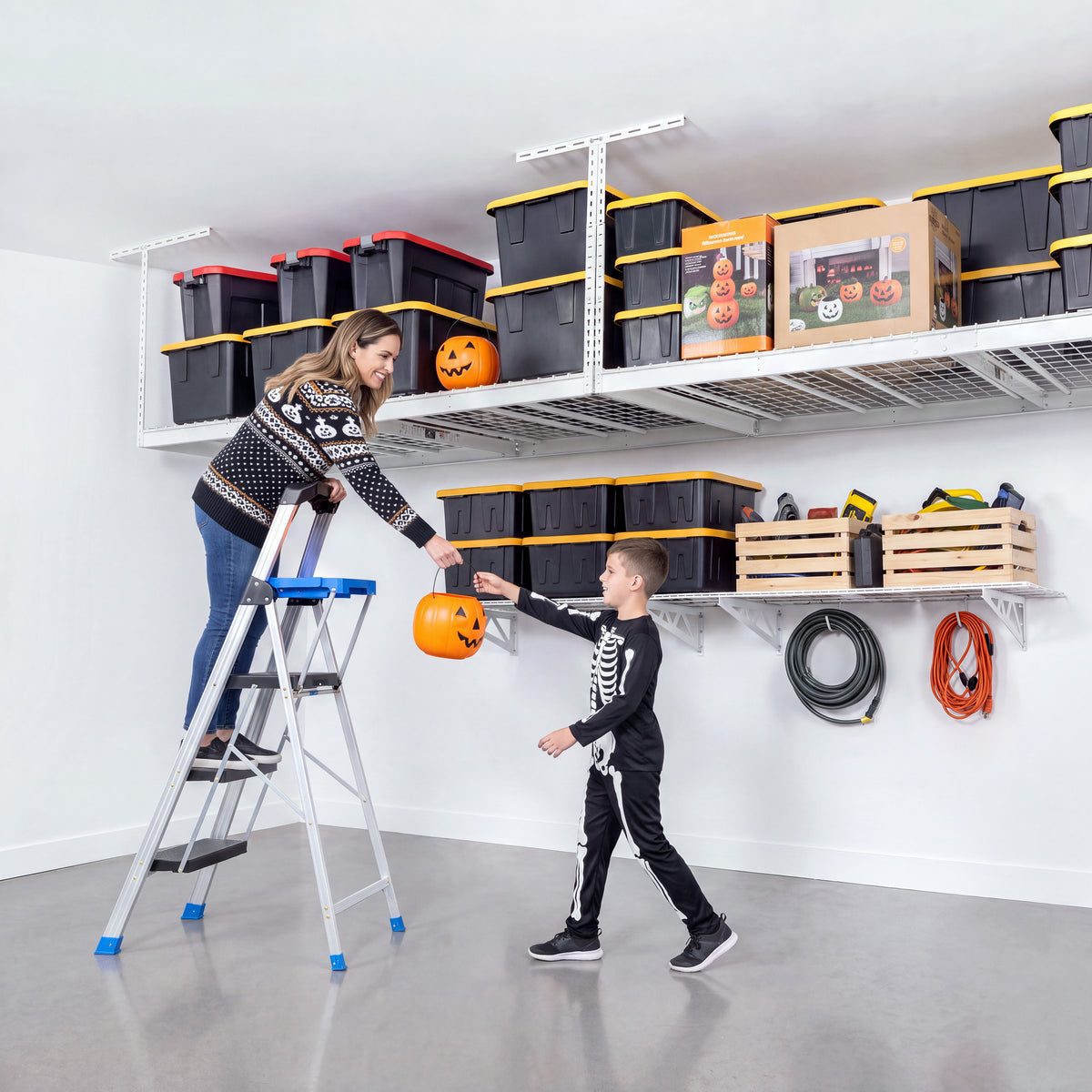 A mother hands her son a trick-or-treating basket that was stored on an overhead rack.