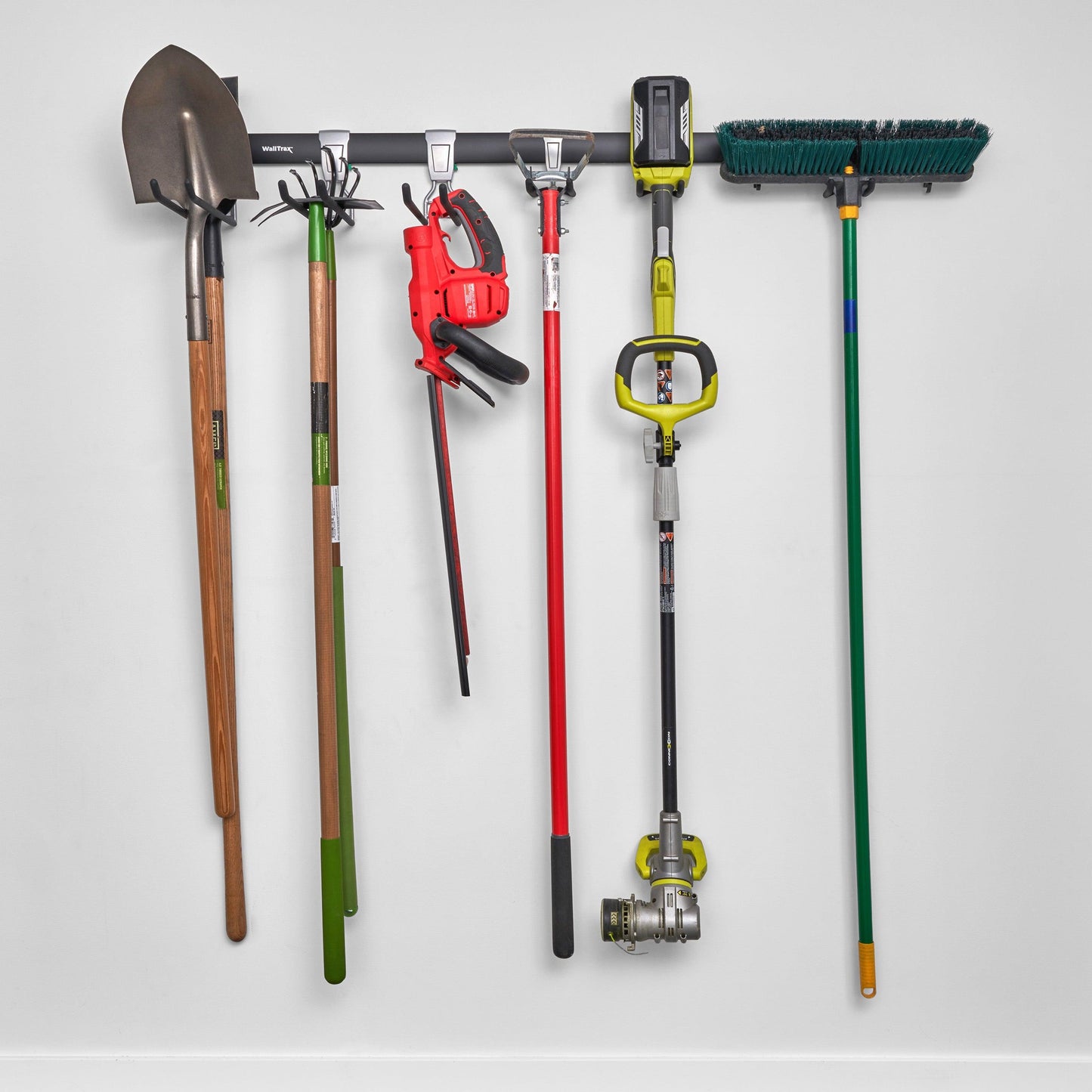 garage track system with adjustable hooks loaded with shovels, brooms, and gardening equipment (7726746403030)