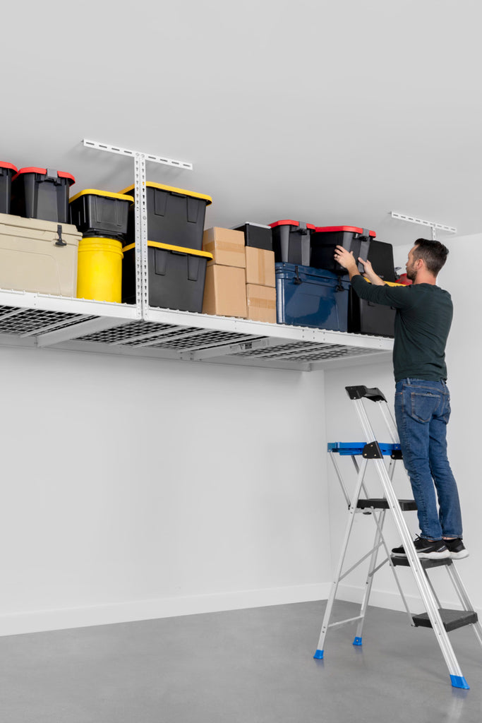 person on ladder removing storage bin from ceiling mounted shelf