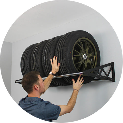 man placing tires on tire rack 