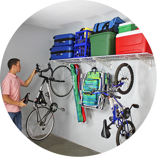 person removing bicycle from loaded wall shelves
