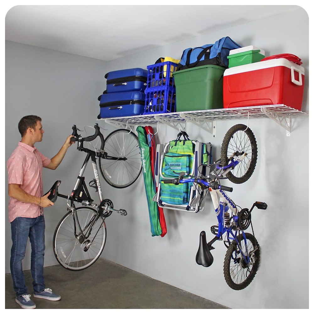 person removing bike from white wall shelves